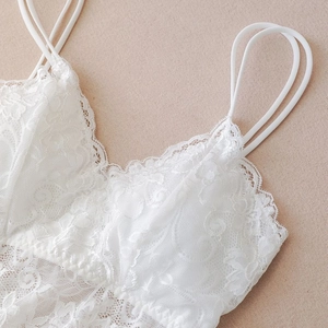 Close-up of white floral lace detail and dual straps on summer camisole top