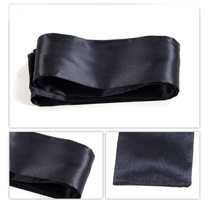 Close-up of black satin eye mask ribbon showing smooth silk texture and fine stitching detail