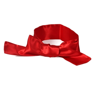 Close-up of a vibrant red satin ribbon blindfold with a smooth silk-like finish