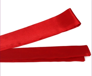 Close-up of a long dark red satin ribbon with a glossy silk texture and fine edges