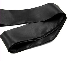 Detail of glossy black satin ribbon accessory with a smooth and luxurious texture