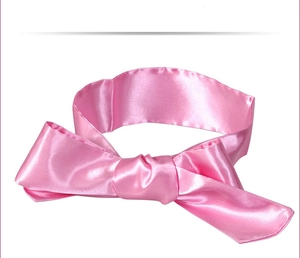 Close-up of pink satin bow blindfold with smooth glossy texture for lingerie