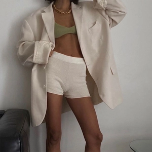 Vue détaillée du look superposé avec blazer crème oversize et débardeur vert tricoté