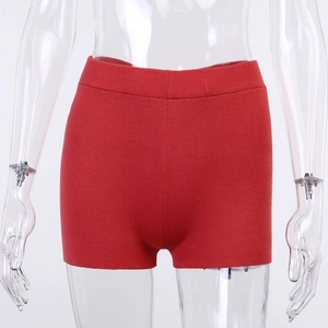 Détail du short en maille rouge à taille haute avec texture côtelée sur fond blanc pur