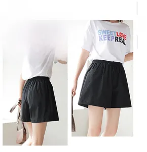 Detail view of black high waist loose shorts with elastic drawstring waistband and side pockets