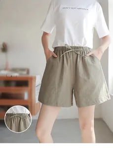 Close-up of light green cotton texture shorts with elastic waist and drawstring detail