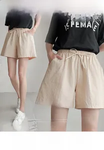 Detailed close-up of apricot high-waist elastic shorts with drawstring and side pockets