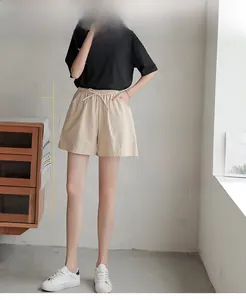 Close-up of apricot wide-leg shorts featuring an elastic drawstring waist and side pockets