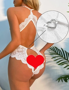 Detailed close-up of white lace bodysuit featuring a crystal heart buckle and open back