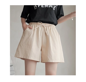 Detail view of beige high-waisted cotton linen shorts with elastic waist and drawstring tie