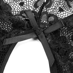 Macro detail of black floral lace fabric with a delicate satin ribbon bow decoration