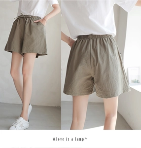 Detail view of olive green cotton crepe shorts with drawstring waist and loose fit