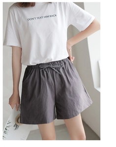 Detail of loose-fitting charcoal grey cotton shorts with elastic drawstring waistband