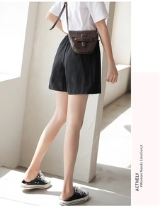 Relaxed fit black high-waist shorts paired with a brown embossed crossbody bag