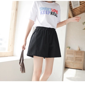 Detail view of high-waisted black cotton wide-leg shorts with drawstring and elastic waist