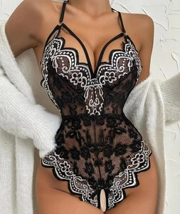 Dettaglio body in pizzo nero con ricamo bianco e profondo scollo a V sensuale