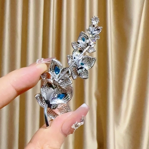 Dettaglio della spilla a foglia con cristalli blu e chiusura a spilla in argento sul retro