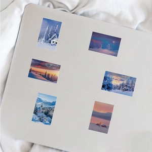 Detail of waterproof winter snow landscape stickers on laptop with white fabric background