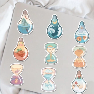 Detail of artistic waterproof stickers with light bulb and hourglass motifs on a laptop