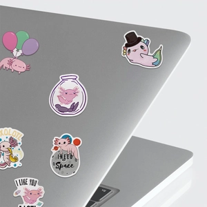 Detailed view of pink cartoon axolotl stickers applied on a grey laptop surface