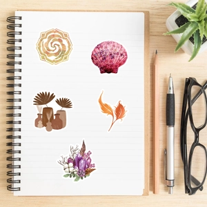 Close-up of bohemian style stickers applied to a spiral notebook on a wooden desk