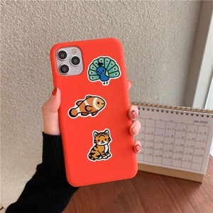 Close-up of cute cartoon animal stickers on a vibrant orange silicone smartphone case