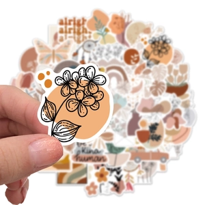 Close-up of a hand holding a matte Bohemian style waterproof sticker with floral patterns