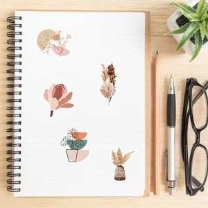 Detail of boho aesthetic stickers on a notebook featuring floral and botanical designs