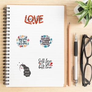Close-up of Self Love inspirational stickers on a notebook with desktop accessories