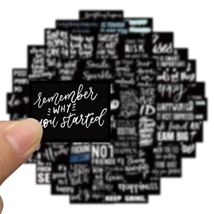 Close-up of waterproof motivational black stickers with white typography for laptops
