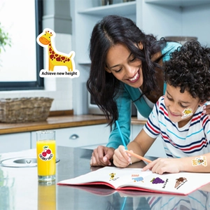Mère et enfant utilisant des autocollants de récompense colorés lors d'un moment ludique