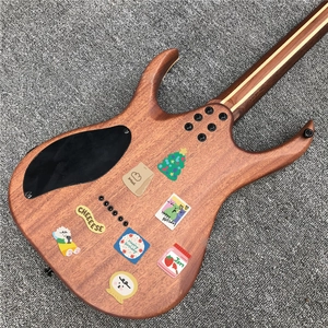 Close-up of cute cartoon stickers on the natural wood grain back of an electric guitar