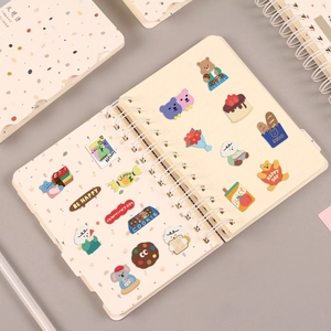 Close-up of cute cartoon bear stickers on a double-coil spiral notebook with index tabs