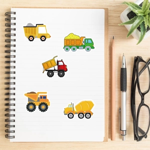 Cartoon construction truck stickers on a notebook with stationery and a small plant