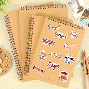 Macro view of autumn-themed stickers applied on a vintage kraft paper notebook