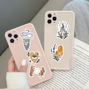 Gros plan de coques de téléphone mates avec gribouillis mystiques et autocollants