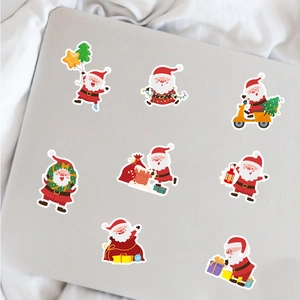 Close-up of waterproof cartoon Santa Claus stickers applied on a laptop surface