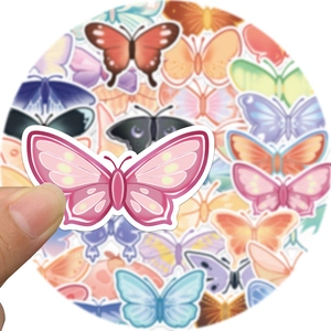 Close-up of a person holding a pink butterfly sticker over a colorful waterproof set