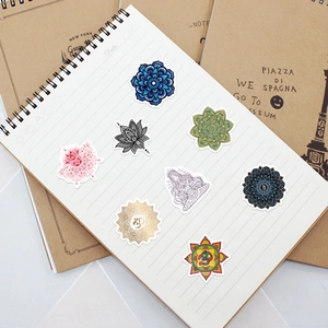 Huit autocollants mandala yoga colorés appliqués sur une page de carnet blanche