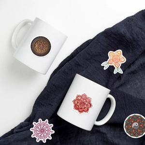 Détail d'autocollants mandala avec motifs lotus et yin yang sur un mug en céramique