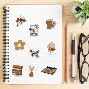 Detailed view of vintage art collage stickers on a notebook featuring floral and Eiffel motifs
