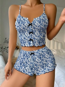 Détail d'un pyjama à fleurs bleues avec nœuds noirs et bordure ondulée