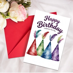 Close-up of minimalist birthday card with watercolor party hats and red envelope