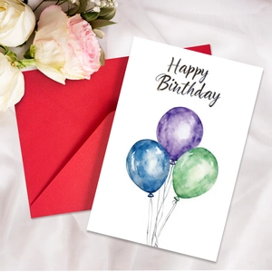 Watercolor balloon birthday card with red envelope on elegant white fabric background