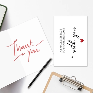 Detail of Thank You greeting card set with red script and small message card on desk