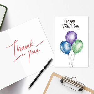Detail of watercolor birthday card with balloons and thank you card on a wooden clipboard