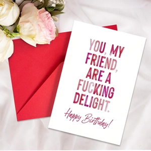 Close-up of minimalist birthday card with purple text and a vibrant red envelope
