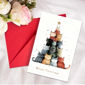 Macro shot of creative Christmas card featuring stacked cats tree and red envelope