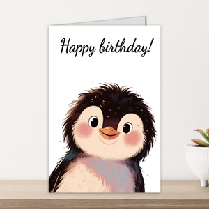 Detailed view of a cute cartoon penguin birthday card placed on a light wooden stand