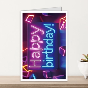 Neon style Happy Birthday card with glowing purple and blue text on a modern wooden shelf